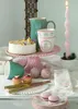 A table setting with a cake, cups, and decorative items. Produktbild-Vorschau