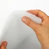 A hand is holding white batting or padding. Produktbild-Vorschau