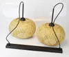 Two pendant lights with natural bamboo shades and black cords are displayed on a white surface. Produktbild-Vorschau