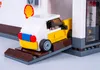 A Lego model of a Shell gas station with a car on a ramp. Podgląd zdjęcia produktu