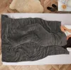 A person is sleeping under a weighted blanket on a bed. Produktbild-Vorschau