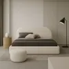 A modern bedroom with a beige upholstered bed, two pillows, and a floor lamp. Anteprima dell’immagine prodotto