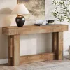 A wooden console table with a lamp and decorative items on top, placed in a room with a painting and a plant. Produktbild-Vorschau