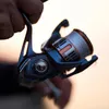 A close-up shot of a fishing reel being held by a person. Produktbild-Vorschau