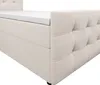 A close-up, side view of a cream-colored box spring bed with a white mattress topper. Produktbild-Vorschau