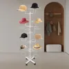 A white hat stand with multiple hats displayed on it, in a room with a wooden wall feature and a bench. Produktbild-Vorschau
