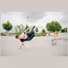 A person breakdancing in a skatepark while another person films them. Náhľad obrázku produktu