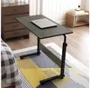 A laptop table is placed next to a bed, with a laptop on top. The room also features a dresser and a small side table. Produktbild-Vorschau