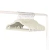 A stack of beige velvet hangers on a white clothing rack. Anteprima dell’immagine prodotto