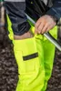 A person wearing high-visibility work pants and jacket, holding a metal pole. Produktbild-Vorschau