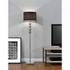 A floor lamp with a black shade and a silver base is shown in a room with a framed picture and a TV stand. Produktbild-Vorschau