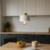 A modern kitchen scene with a pendant light hanging over a wooden table. Náhled obrázku produktu