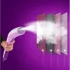 A hand holds a pink and white garment steamer, emitting steam that passes through layered fabric swatches. The background is a solid purple. Náhled obrázku produktu