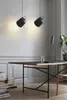 A modern office or study space with a desk, books, and pendant lights. Voir les images du produit
