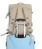 A beige backpack is placed on top of a light blue suitcase. Anteprima dell’immagine prodotto