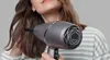 A woman is drying her hair with a hairdryer. Anteprima dell’immagine prodotto