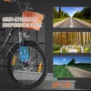 A close-up of an electric bicycle's front wheel and suspension, with inset images of scenic roads and a forest path. Produktbild-Vorschau