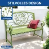 A green metal garden bench with ornate scrollwork and leaf motifs, placed outdoors on a patio with a pillow on the seat. Podgląd zdjęcia produktu