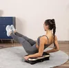 A woman is exercising on a vibration plate in a room. Náhľad obrázku produktu