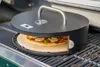 A pizza oven accessory is shown on a grill, cooking a pizza. Náhľad obrázku produktu