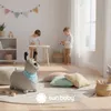 Two children playing in a bright, airy room with toys and soft furnishings. Produktbild-Vorschau