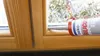 A tube of silicone sealant is being used to seal a wooden window frame. Produktbild-Vorschau
