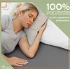 A woman sleeping on a bed with pillows. Produktbild-Vorschau