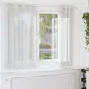 A white voile curtain hangs on a window, with a radiator visible below. Voir les images du produit