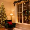 A cozy living room decorated for Christmas, featuring a lit Christmas tree, a green armchair with a red pillow, a floor lamp, and a decorated window with a wreath and garland. Produktbild-Vorschau