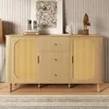 A wooden sideboard with rattan doors and drawers, decorated with artwork and sculptures, placed in a room with a striped rug and textured wall. Voir les images du produit