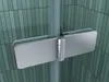 A close-up view of a shower hinge attached to a glass panel, with a tiled wall in the background. Produktbild-Vorschau