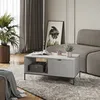 A living room scene with a coffee table, sofa, plant, and artwork. Náhled obrázku produktu