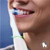 Close-up of a person brushing their teeth with an electric toothbrush. Voir les images du produit
