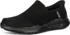 A black Skechers slip-on shoe is shown from the side against a white background. Voir les images du produit