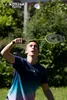 A young man playing badminton outdoors. Produktbild-Vorschau