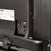 The back panel of a television showing various ports and a label. Produktbild-Vorschau