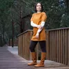 A woman stands on a wooden deck in a forest setting, wearing boots. Voir les images du produit