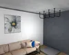 A living room with a sofa, a painting on the wall, and a ceiling-mounted pull-up bar. Produktbild-Vorschau