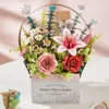 A 3D wooden flower basket model with various flowers and greenery, displayed on a table with a pink background. Anteprima dell’immagine prodotto