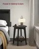 A bedside table with a lamp, candle, and books next to a bed. Produktbild-Vorschau