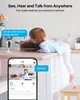 A baby is playing in a kitchen while a security camera monitors the scene, with a smartphone app showing the live feed. Produktbild-Vorschau