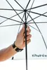 A hand holding the handle of an open umbrella. Produktbild-Vorschau