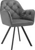A studio shot of a gray velvet armchair with black metal legs.