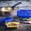 Food items in containers and a pot on a textured surface. Anteprima dell’immagine prodotto
