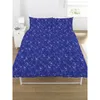 A blue duvet cover with a repeating pattern of chemical element symbols is shown on a bed. Voir les images du produit