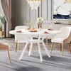 A dining room scene with a white round table set for a meal, surrounded by chairs and decorated with a chandelier and artwork. Náhled obrázku produktu
