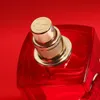 A close-up shot of a red perfume bottle with a gold cap. Podgląd zdjęcia produktu