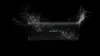 A black Sony Bluetooth speaker is shown against a black background, with white particles exploding outwards from both sides. Voir les images du produit