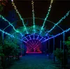 A garden path illuminated by strings of colorful LED lights at night. Náhled obrázku produktu