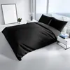 A black duvet cover and pillow set on a bed in a modern bedroom. Produktbild-Vorschau